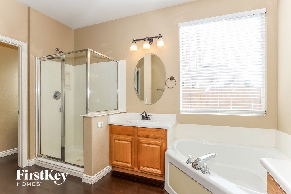 A bathroom with a tub, sink, and shower.