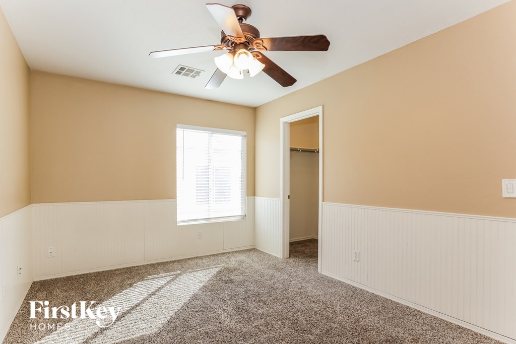 A room with a ceiling fan and a window.