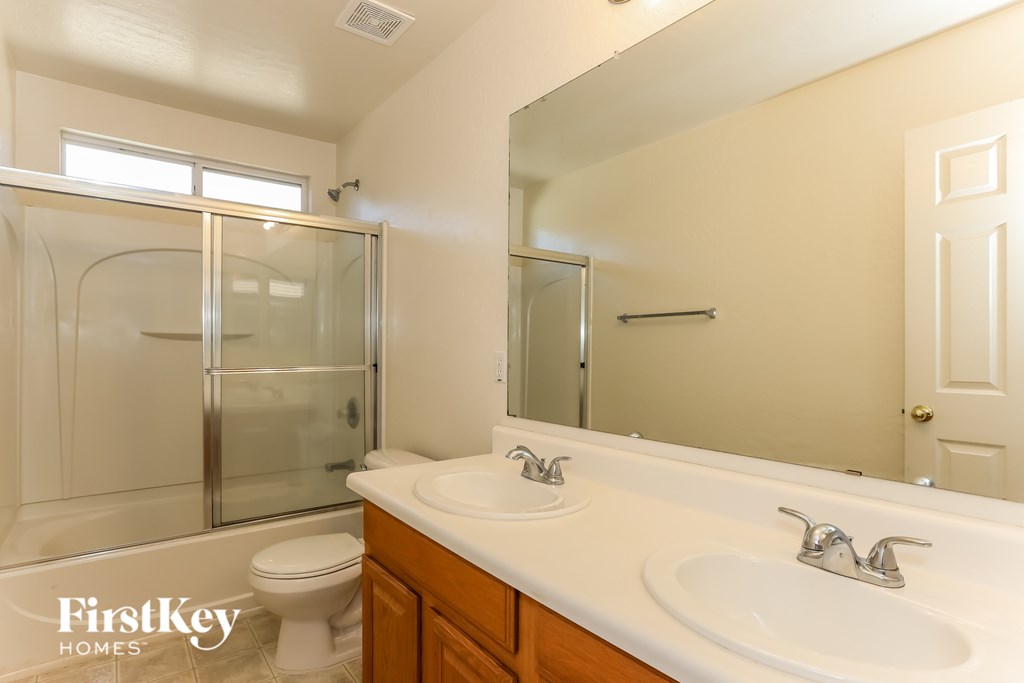 A bathroom with a toilet, sink, and shower.