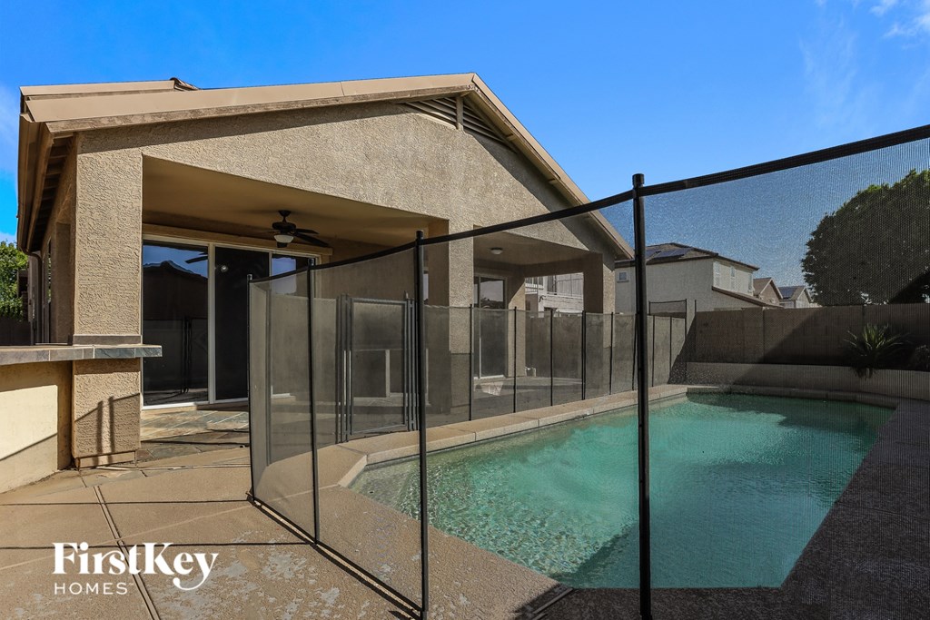 A pool in a house with a glass fence around it.