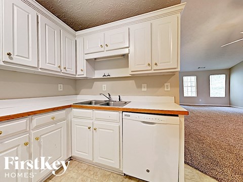 A kitchen with white cabinets and a sink.