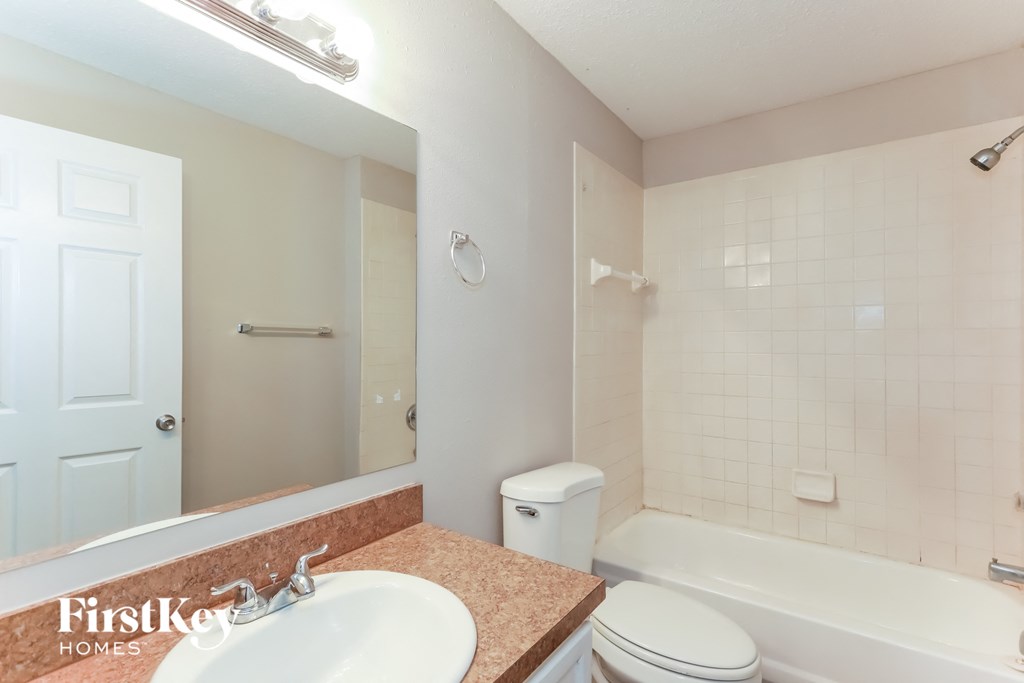 A bathroom with a sink, toilet, and bathtub.