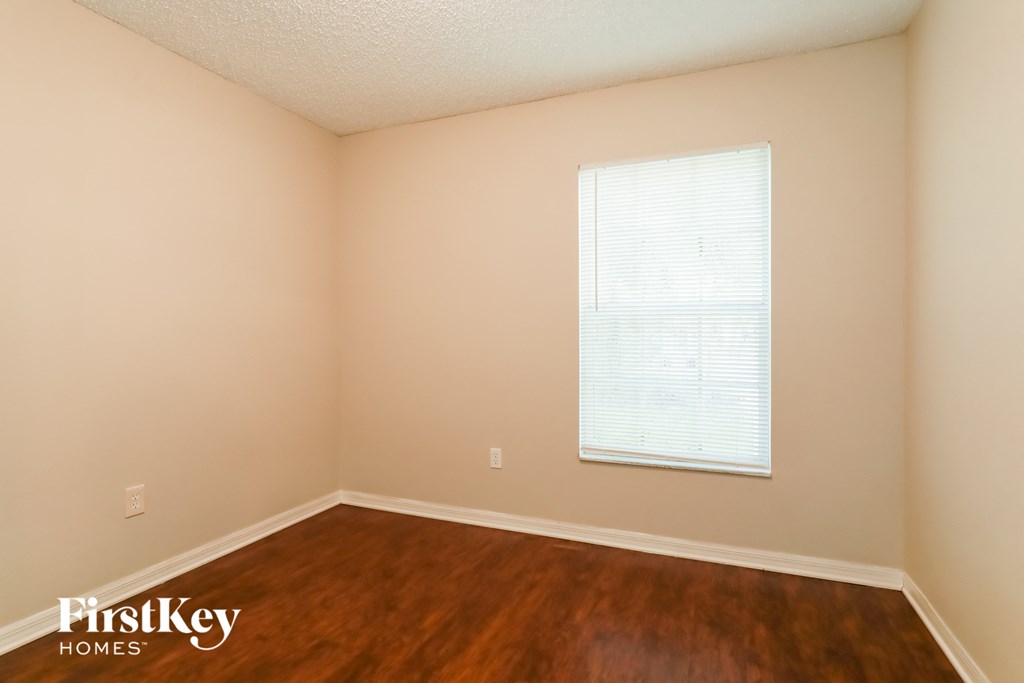 A room with a window and wooden floor.