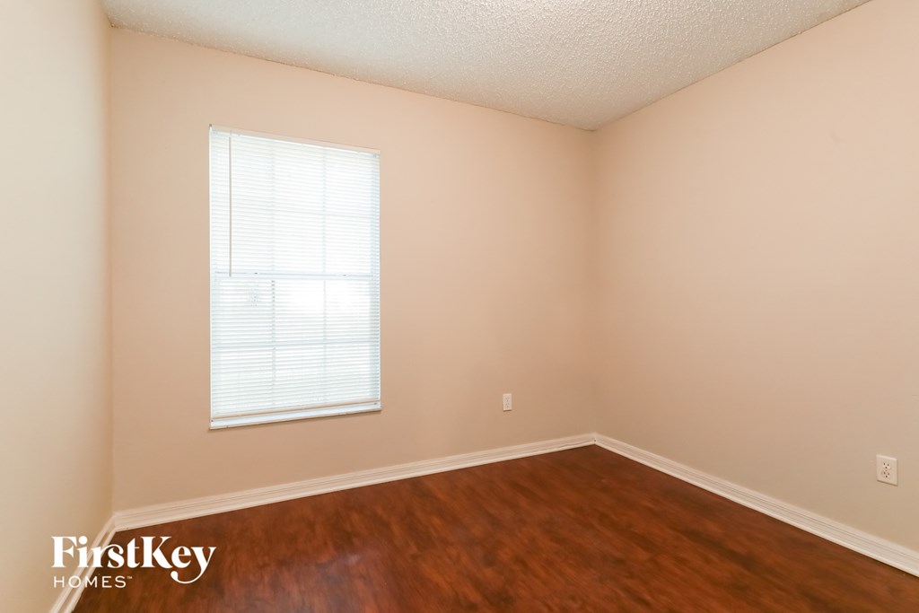 A room with a window and wooden floors.