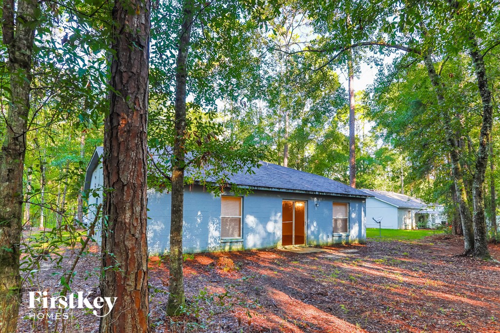 A blue house is surrounded by trees in a forest.