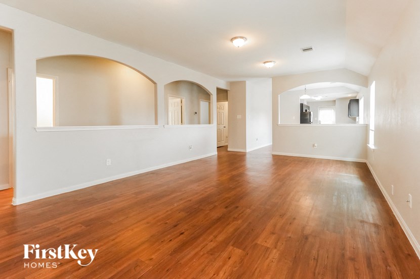 an empty living room with wood floors and white walls