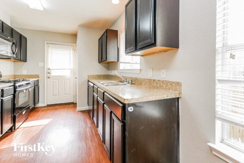a kitchen with black cabinets and white counter tops