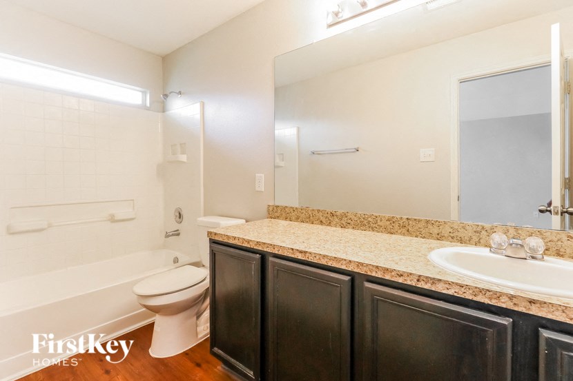 a bathroom with a sink toilet and a mirror