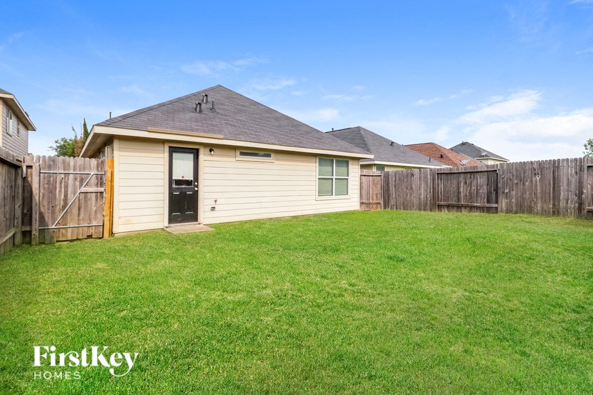 a backyard with a small house with a yard and a fence