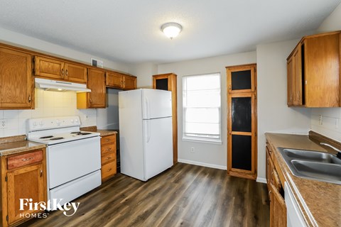 A kitchen with wooden cabinets and a white fridge.