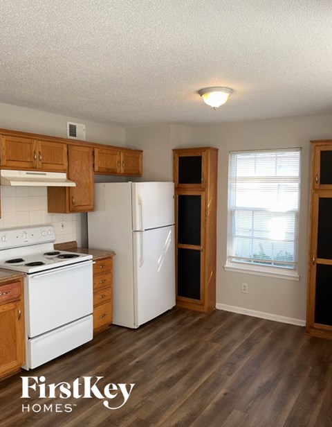 A kitchen with wooden cabinets and a white refrigerator.