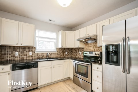A kitchen with a stove top oven and a refrigerator.