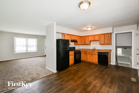 A kitchen with wooden cabinets and black appliances.