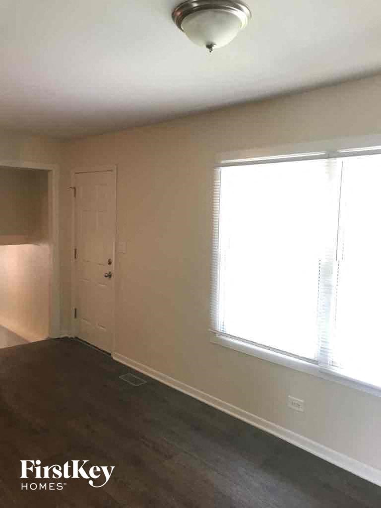 A room with a window and a door is empty and waiting to be furnished.