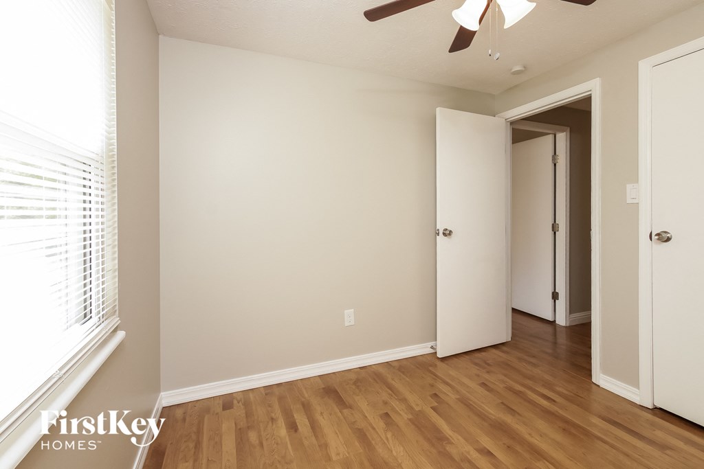 A room with a wooden floor and a ceiling fan.