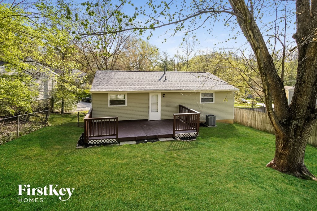 A house with a porch and a tree in front of it.