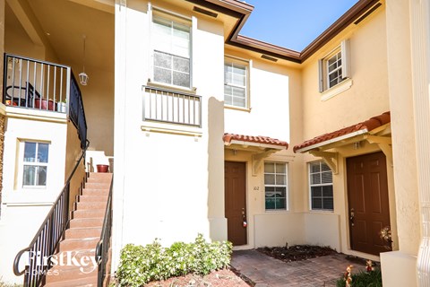 A sunny day at a two-story building with a balcony on the first floor.