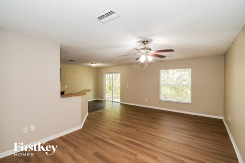 A spacious room with a ceiling fan and sliding glass doors.