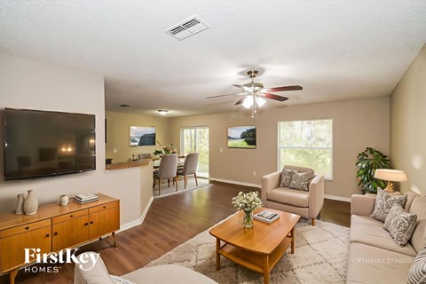 A living room with a wooden floor and a television on the wall.