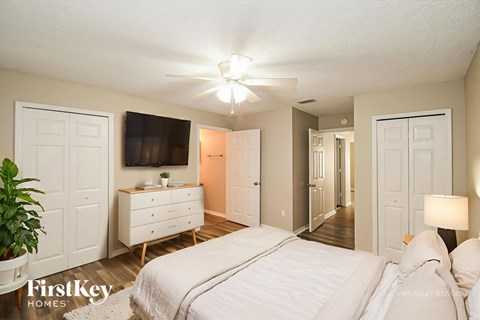 A bedroom with a bed, dresser, and mirror.