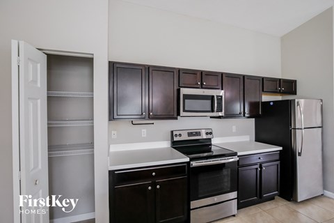 A kitchen with dark brown cabinets and stainless steel appliances.