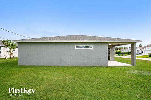 A grey building with a FirstKey HOMES sign in front of it.