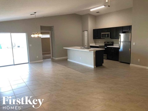 A spacious kitchen with black cabinets and stainless steel appliances.
