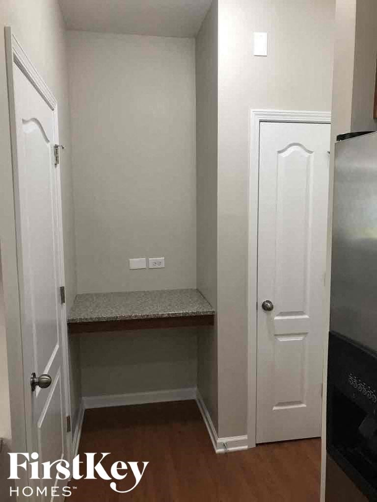 A small white closet with a bench seat and a door to the right.