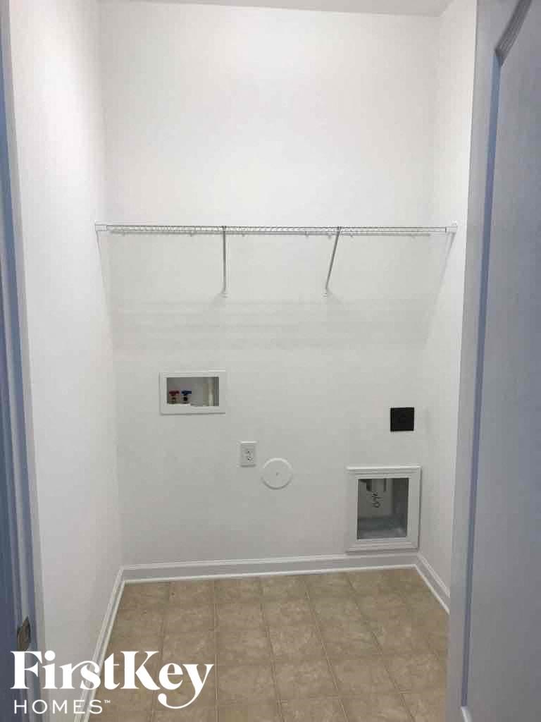 A white wall with a shelf and a small window.