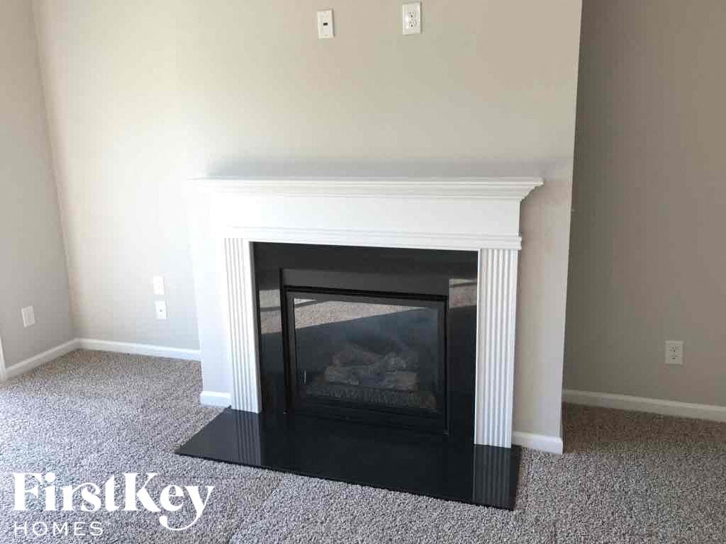 A fireplace in a room with a carpeted floor.