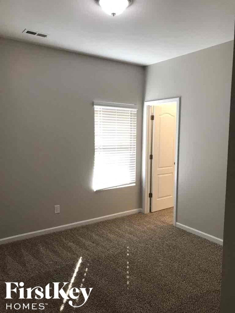 A room with a carpeted floor and a door leading to another room.