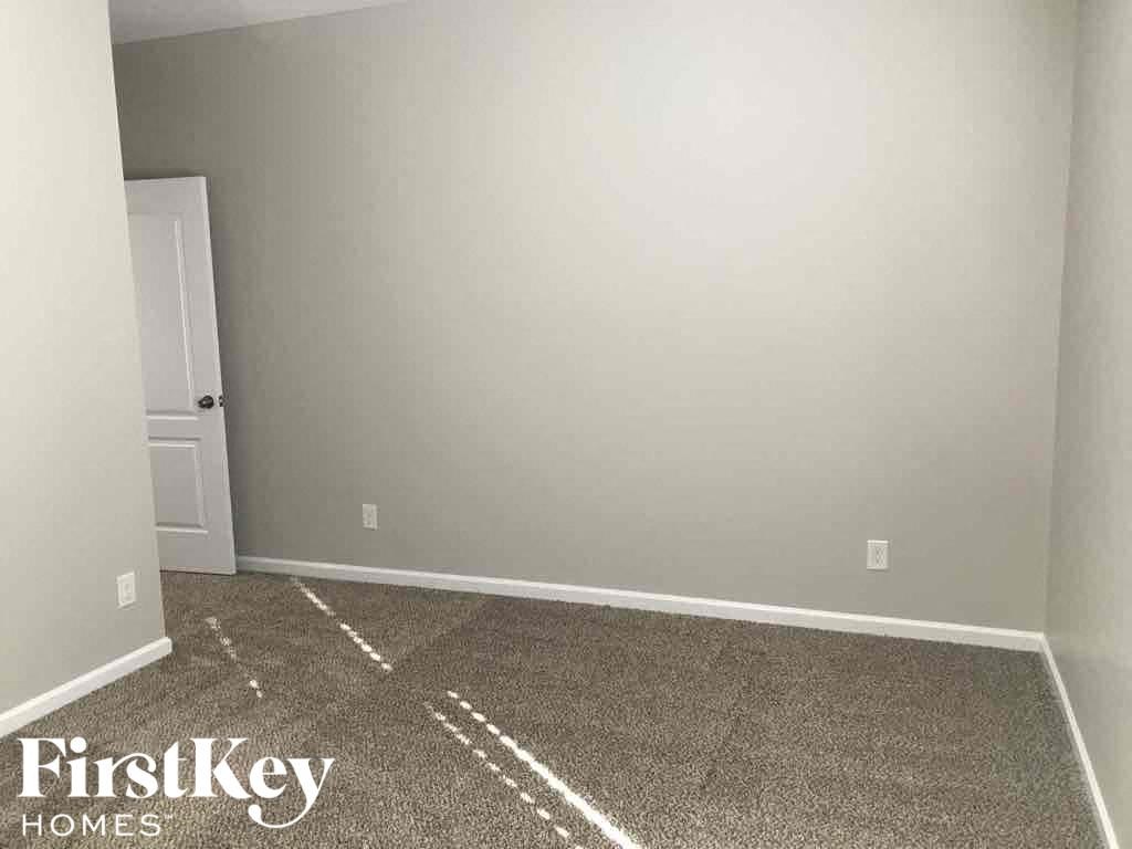 A room with a carpeted floor and a door.