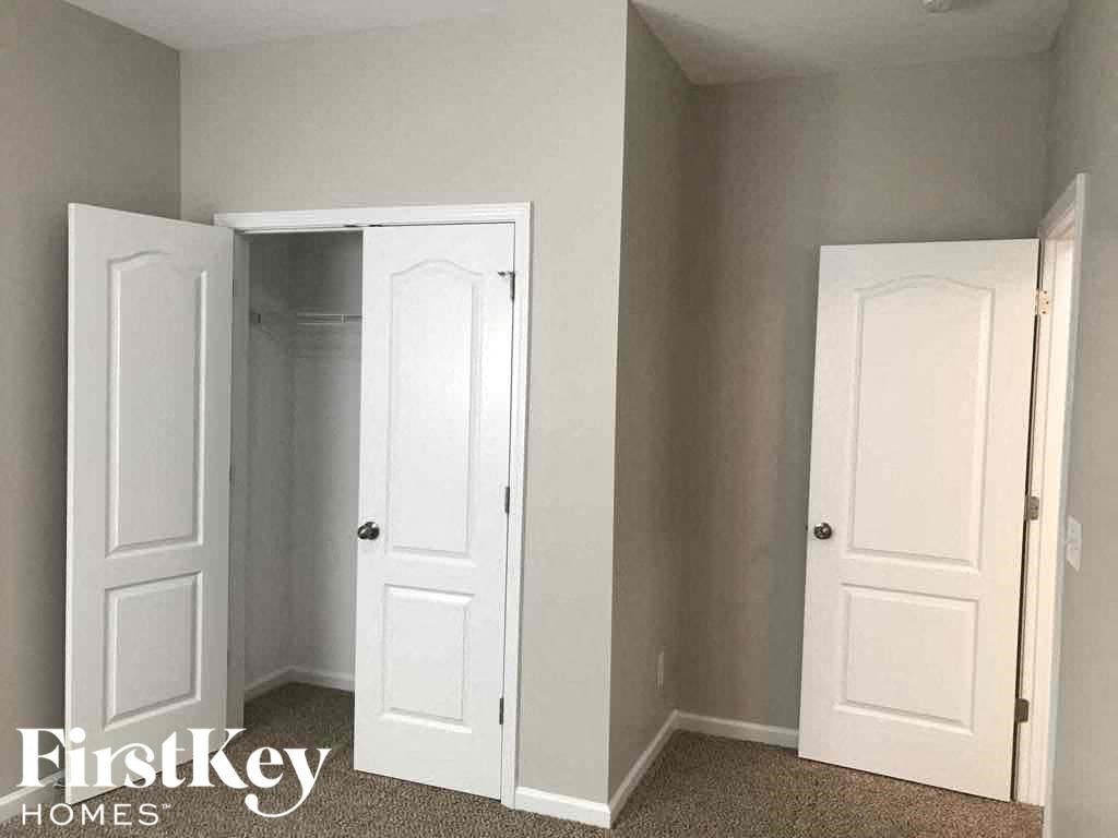 A room with two white doors and a carpeted floor.