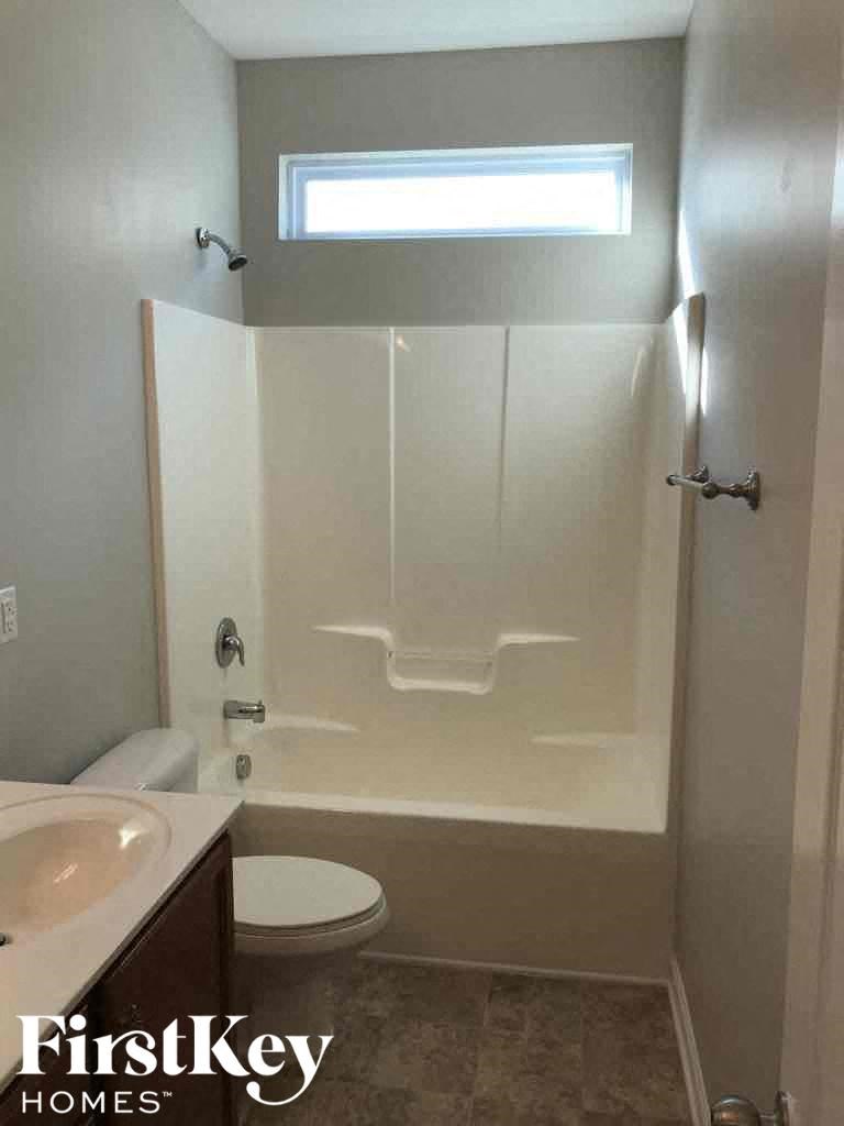 A small bathroom with a walk in shower and a toilet.