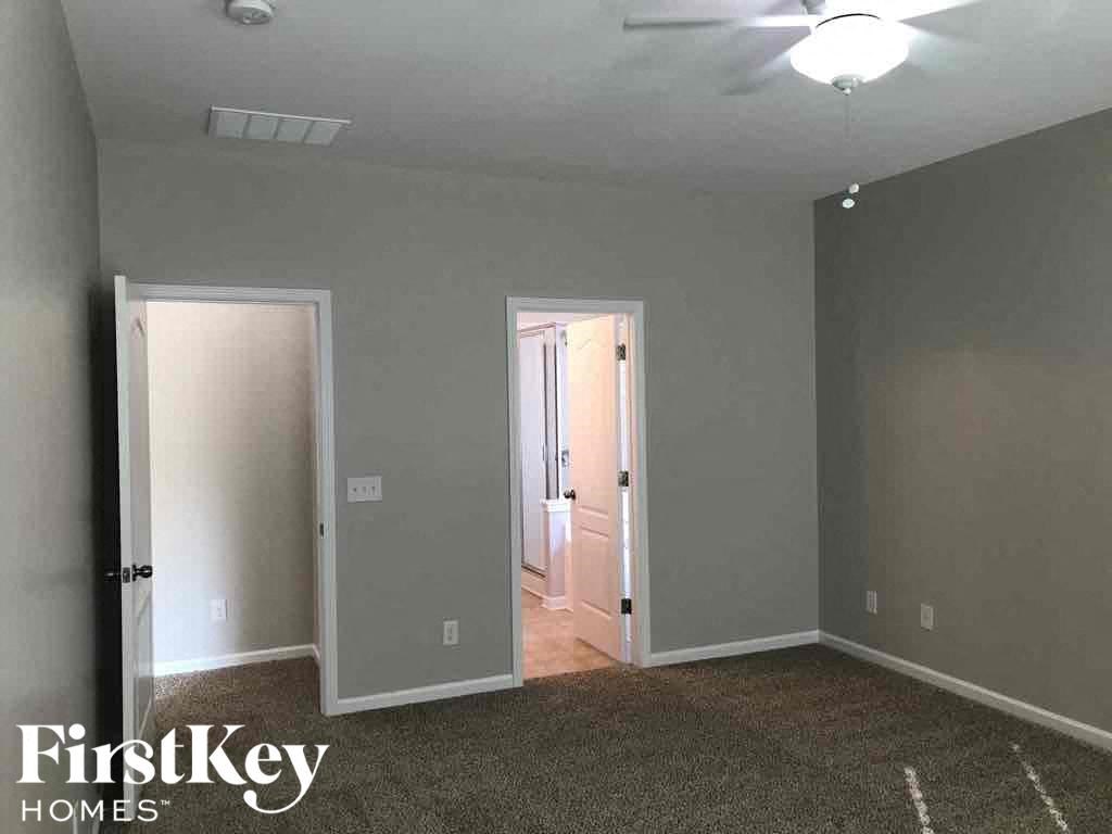 A room with a carpeted floor and two doors.