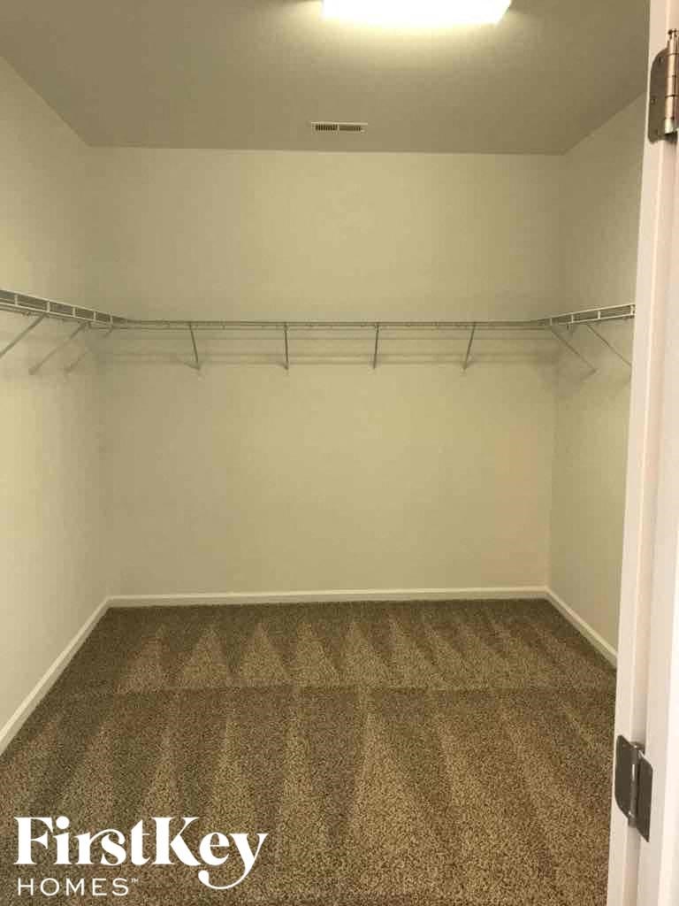 A room with a carpeted floor and a door on the right side.