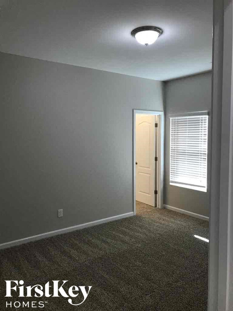 A room with a door and a window with blinds.