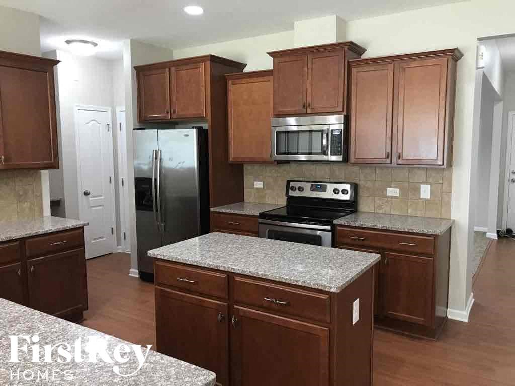 A kitchen with brown cabinets and a granite countertop.