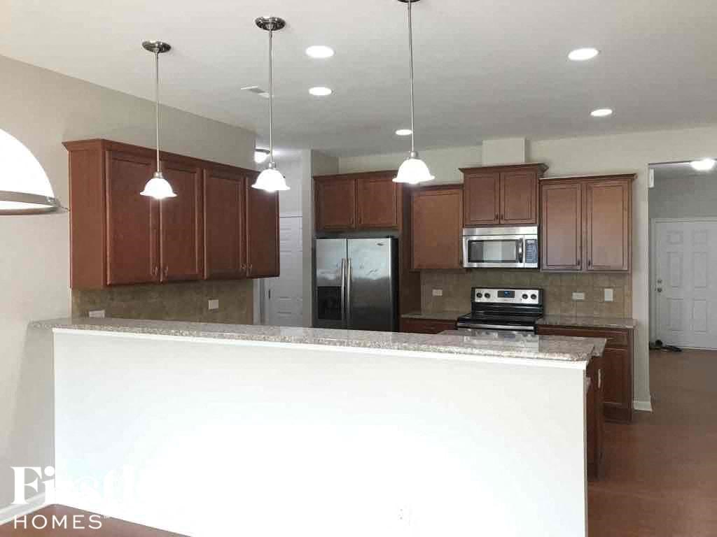 A kitchen with brown cabinets and a white island.