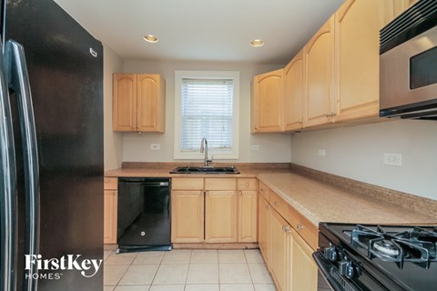 a kitchen with wooden cabinets and black appliances and a window