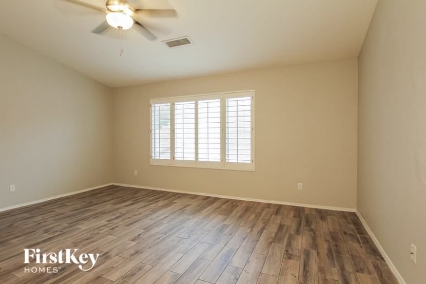 A room with wooden flooring and a ceiling fan.