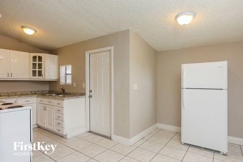 A kitchen with white appliances and cabinets.
