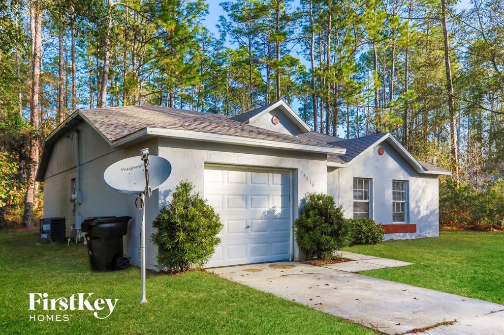 a blue and white house with a satellite dish on the driveway