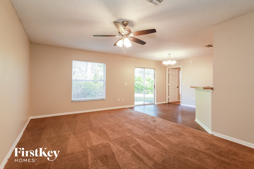 the spacious living room and dining room with a ceiling fan