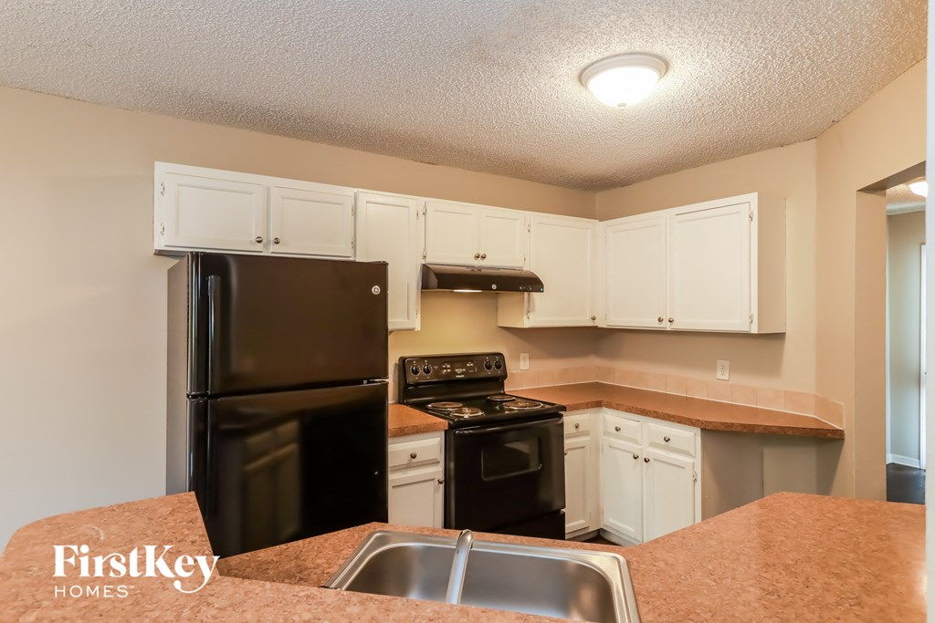 a kitchen with black appliances and white cabinets