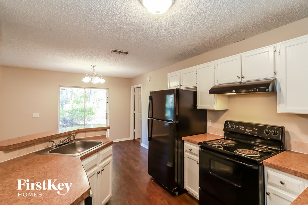 a kitchen with black appliances and white cabinets