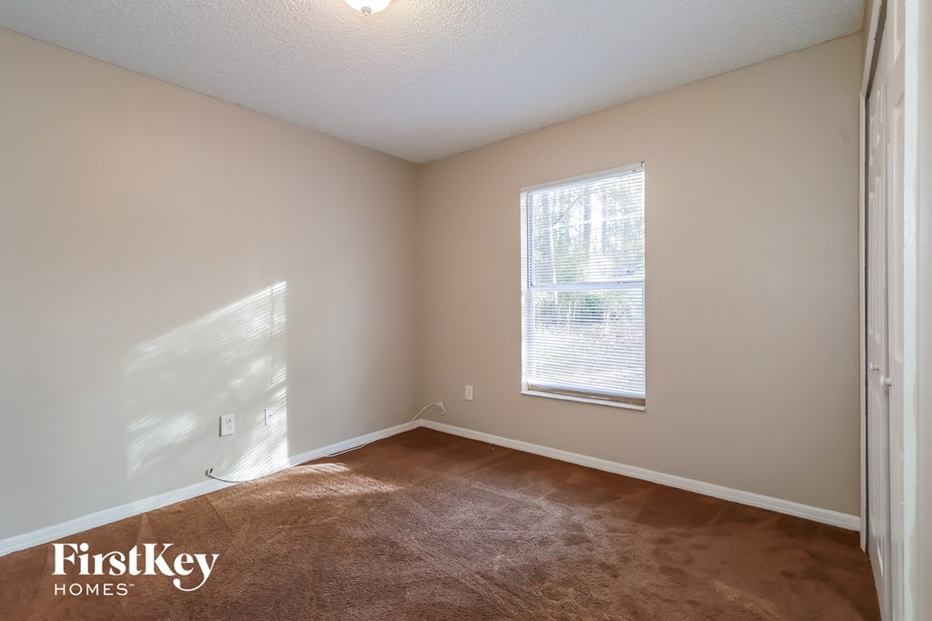 a bedroom with a carpeted floor and a window