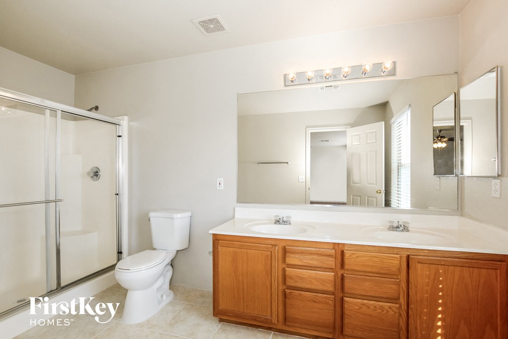 a bathroom with a large mirror and a toilet and a sink