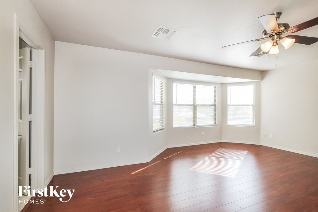 a living room with wood floors and a ceiling fan