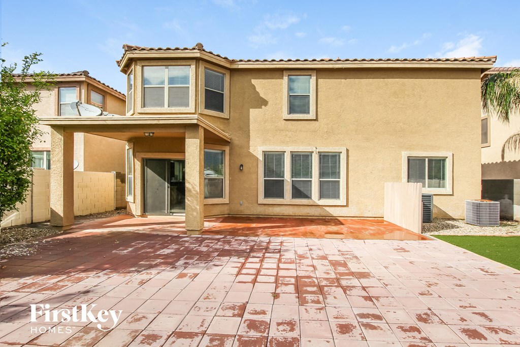 a beige house with a patio and a driveway